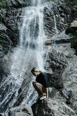young woman on the background of a mountain waterfall with a ponytail 