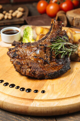 Cowboy beef steak on a wooden board with potatoes