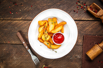 Potato wedges garnish with thyme and ketchup