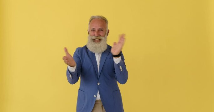Excited senior businessman clapping his hands and cheering
