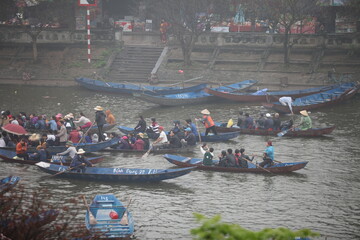 Obraz premium HANOI, VIETNAM - MARCH 30, 2015: Tourist sit on boat to visit HUONG Pagoda. HUONG Pagoda Festival is the biggest and longest annual festival in Vietnam. The festival is opened in MY DUC district