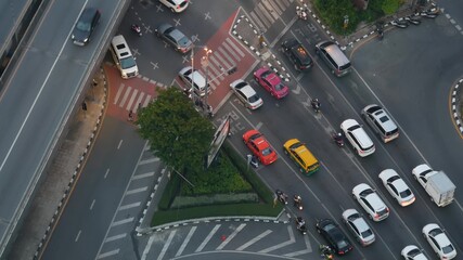 Traffic on crossroad on street. From above modern cars and motorcycles driving on intersection on street in center of Bangkok, Thailand