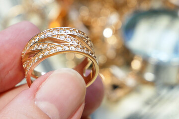 jewelry scrap of gold and silver and money, pawnshop concept jeweler looking at jewelry through...