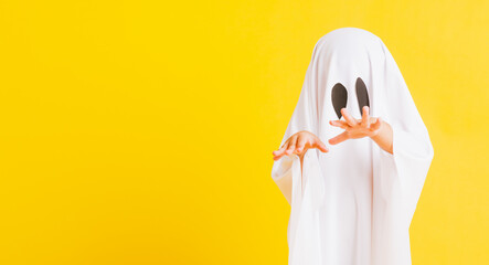 Funny Halloween Kid Concept, Closeup a little cute child with white dressed costume halloween ghost...
