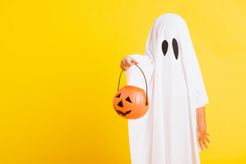 Funny Halloween Kid Concept, little cute child with white dressed costume halloween ghost scary he...