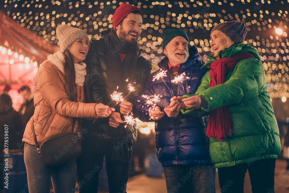 Poster Portrait of nice attractive cheerful family having fun spending time street urban market newyear celebration burning bengal festal fire custom eve noel spirit outside outdoor