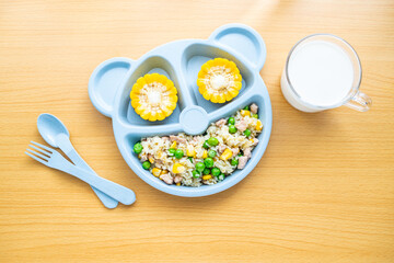 A plate of fried rice with diced meat for children's nutrition meal on the table