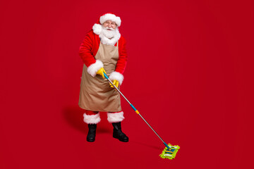 Full length photo of white grey hair bearded santa claus wash floor mop x-mas cleaning wear apron red costume headwear cap isolated bright shine color background