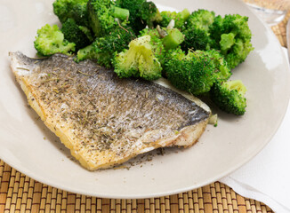 dish of fried dorado fish fillet with boiled broccoli