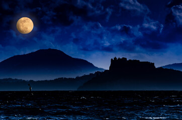Island of Procida, Campania region, Italy. Image of the island with a castle silhouette seen from a...