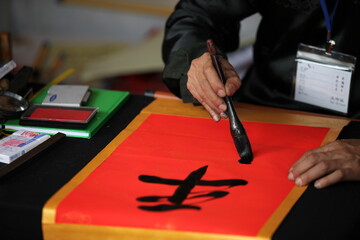 Hanoi, Vietnam -  Calligrapher writing words on paper. Calligraphy is old culture of Vietnam