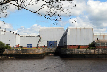 Fototapeta na wymiar River View with Large Industrial Buildings