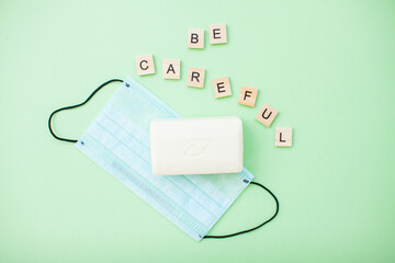 Obraz premium inscription from wooden blocks be careful and soap and protective medical mask