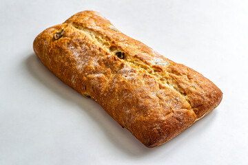 Fresh Italian white ciabatta bread with olives on a white background