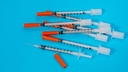 Insulin vial and syringe on blue background. Health care, doctor, clinic or hospital, medical concept. World diabetes day. Ready for vaccine injection. Pain treatment, illegal use, vaccination
