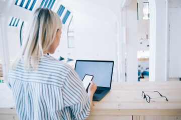 Woman using smartphone with blank screen in library