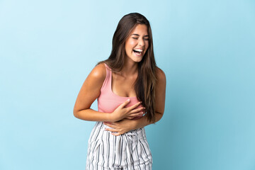 Young brazilian woman isolated on blue background smiling a lot