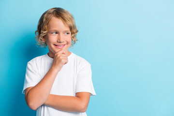 Photo of small kid hand chin face curly hairstyle beaming smile look empty space wear white shirt...