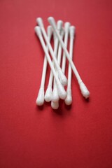 white cotton swabs on the red background,  hygiene products