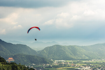 colorful paragliding over blue sky at town