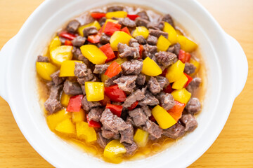 A dish of diced beef with colored pepper