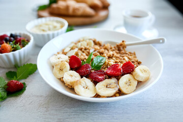 Healthy breakfast bowl, fresh granola, muesli with yogurt fruits and coffee, strawberry, banana on white table, Copy space. Clean eating, detox, dieting, vegetarian food concept