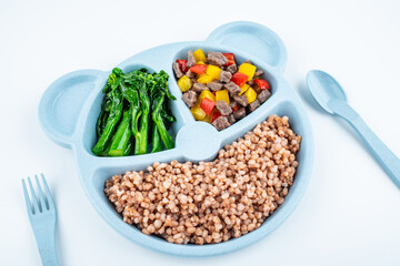 Nutritional meal for children on a plate on white background