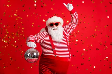  Photo of retired old man grey beard hold vintage disco ball dance funky wear santa x-mas costume suspenders sunglass gloves striped shirt cap isolated red color background © deagreez