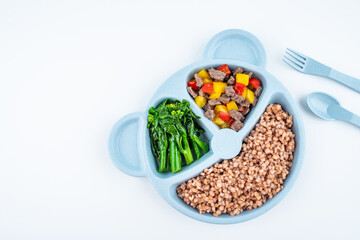 Nutritional meal for children on a plate on white background