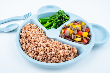 Nutritional meal for children on a plate on white background