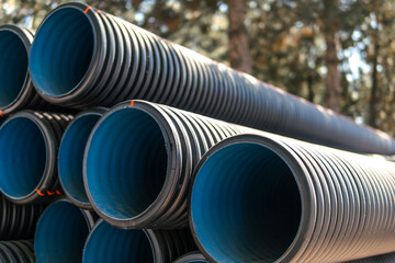 Corrugated water pipes of large diameter prepared for laying, copy space