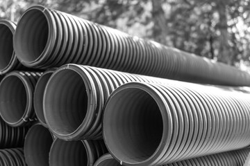 Black and white. Corrugated water pipes of large diameter prepared for laying