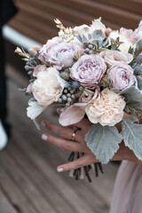 Bride holding beautiful flower bouquette on wedding day close up shot.