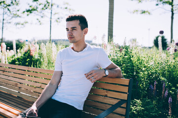 Young man sitting on bench in park