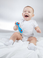 Photo of a ten-month-old child with blue rattle