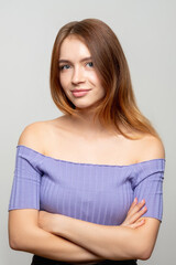 Fototapeta premium Confident woman portrait. Female success. Ambitious lady with natural makeup in purple top standing with folded arms looking at camera isolated on light background. Determination leadership.