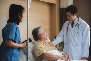 Asian doctor and nurse talk with old patient about disease symptom with stethoscope for elderly health check up