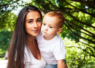 young pretty brunette mother with little cute boy walking in park happy smiling, lifestyle people concept