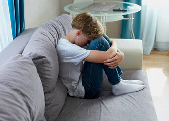 teenage boy suffer from cyberbullying, offended boy sit alone at home. autism, problems, children...