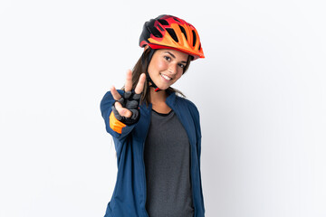 Young cyclist brazilian girl isolated on white  background happy and counting three with fingers