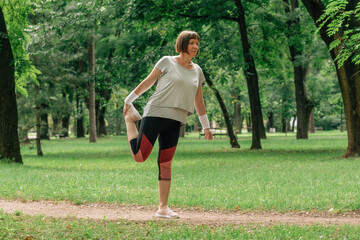 Female jogger stretching muscles and warming up for running exercise in park