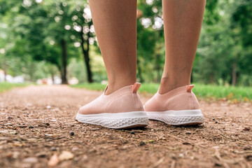 Female jogger preparing for running down the path in park