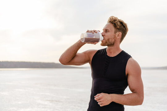 Image of young athletic sportsman drinking protein shake