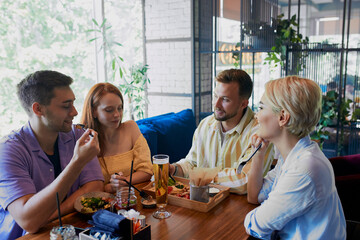 two married couples got together in a restaurant, spend free time in weekends. have meal and talk. friendship, people, communication concept