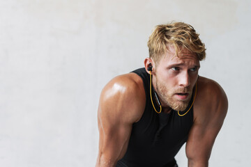 Obraz premium Confident young sports man listening to music