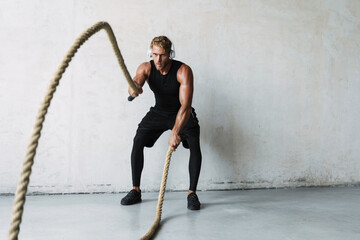 Attractive young sporty man in headphones exercising