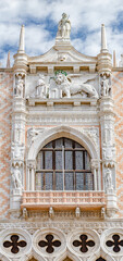 Magnificent main facade with luxurious balcony and statues with roof decorations of Doge Palace in...