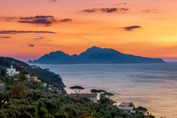 Massa Lubrense, Italy. January 12th, 2011. Breathtaking sunset on the island of Capri. The coast of Massa Lubrense in foreground.