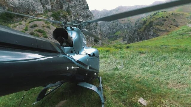 The helicopter takes off and flies over a mountain lake. View from the tail of the helicopter in 4K