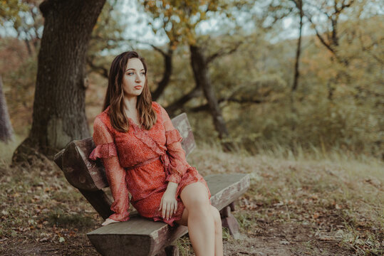 Woman sist on banch in park in golden autumn